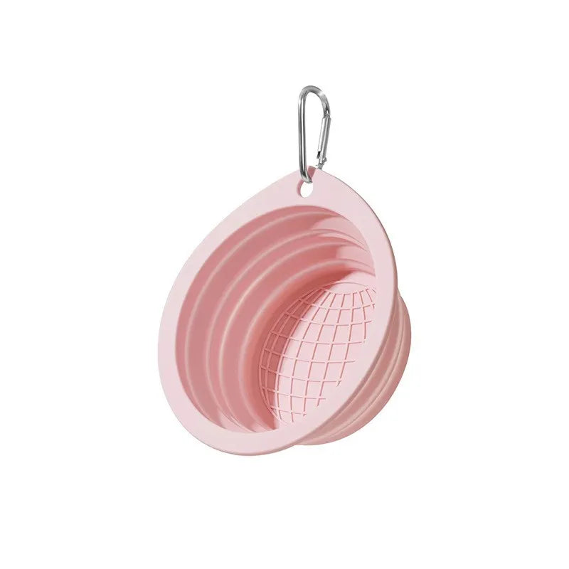 A pink collapsible silicone pet travel bowl with a wire mesh insert and a hanging loop.