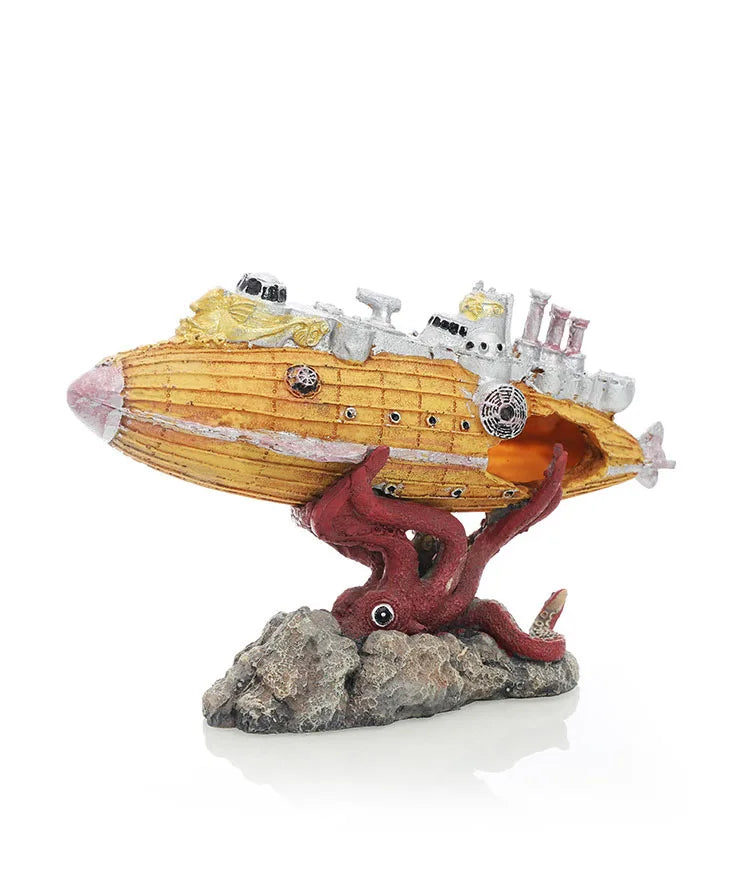 A model of a yellow submarine with a reddish creature emerging from a rock base.