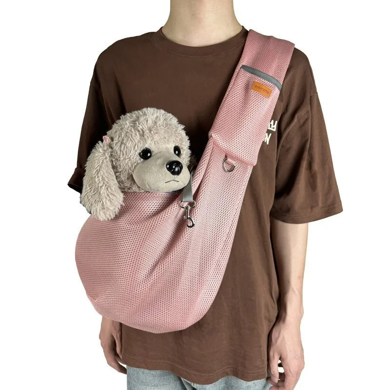 A brown t-shirt features a pink breathable mesh dog carrier crossbody bag with a fluffy dog toy inside.