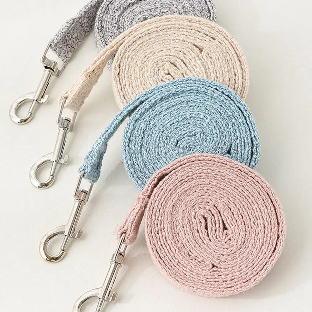 A stack of beige, gray, and blue pet leash harnesses coiled together.