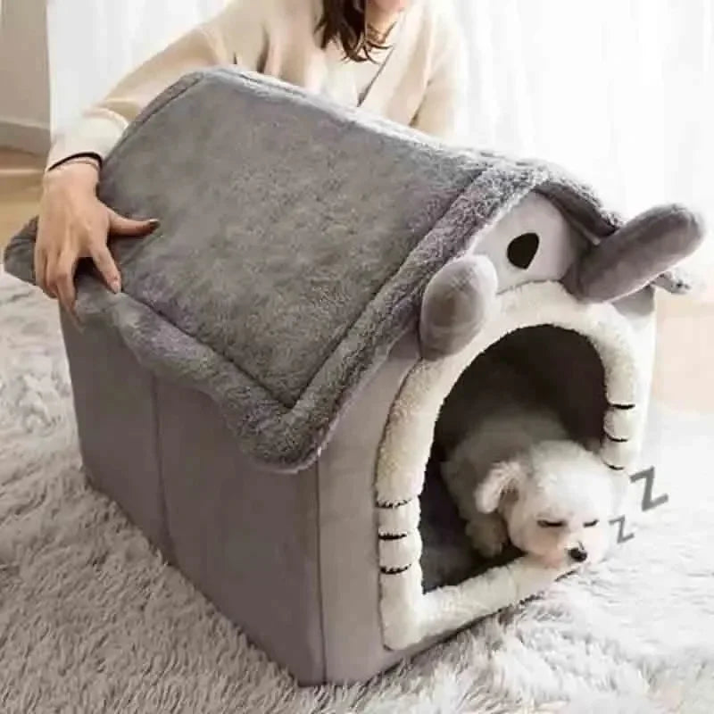Tente grise pour animal de compagnie avec entrée ronde, où repose un petit chien blanc sur un tapis moelleux.
