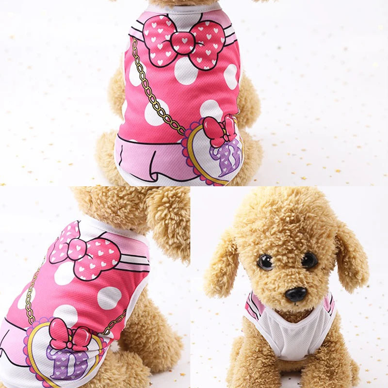 Un chien duveteux portant un gilet à pois rose et blanc avec un nœud rose et un collier en chaîne dorée.
