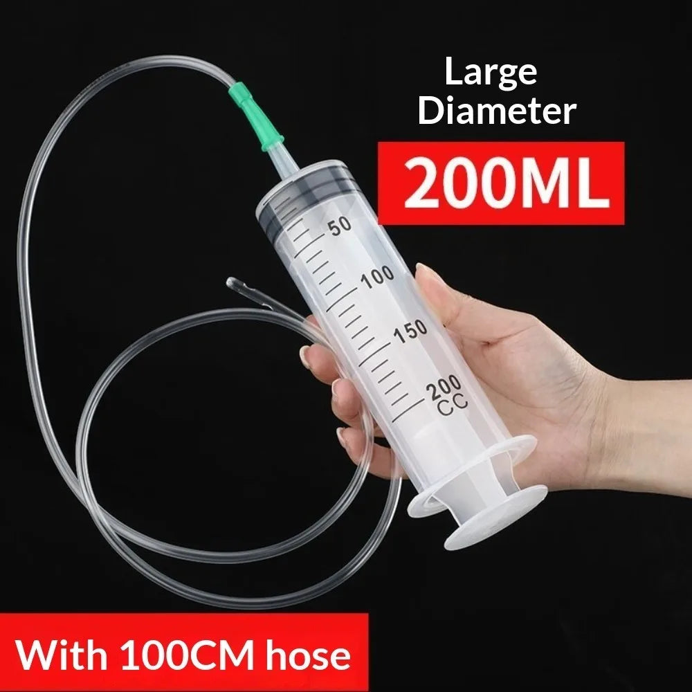Eine Hand hält eine große 200ml Plastikspritze mit einer 100cm Schlauch für die Ölextraktion.