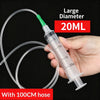 Eine Hand hält eine große 20ml Plastikspritze mit einer 100cm Schlauch für die Ölextraktion.