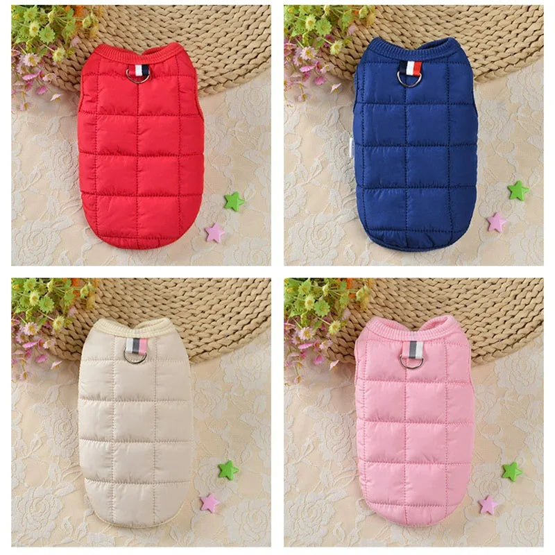 Trois manteaux pour chiens rembourrés en tissu matelassé rouge, bleu et rose, présentés sur un fond clair.