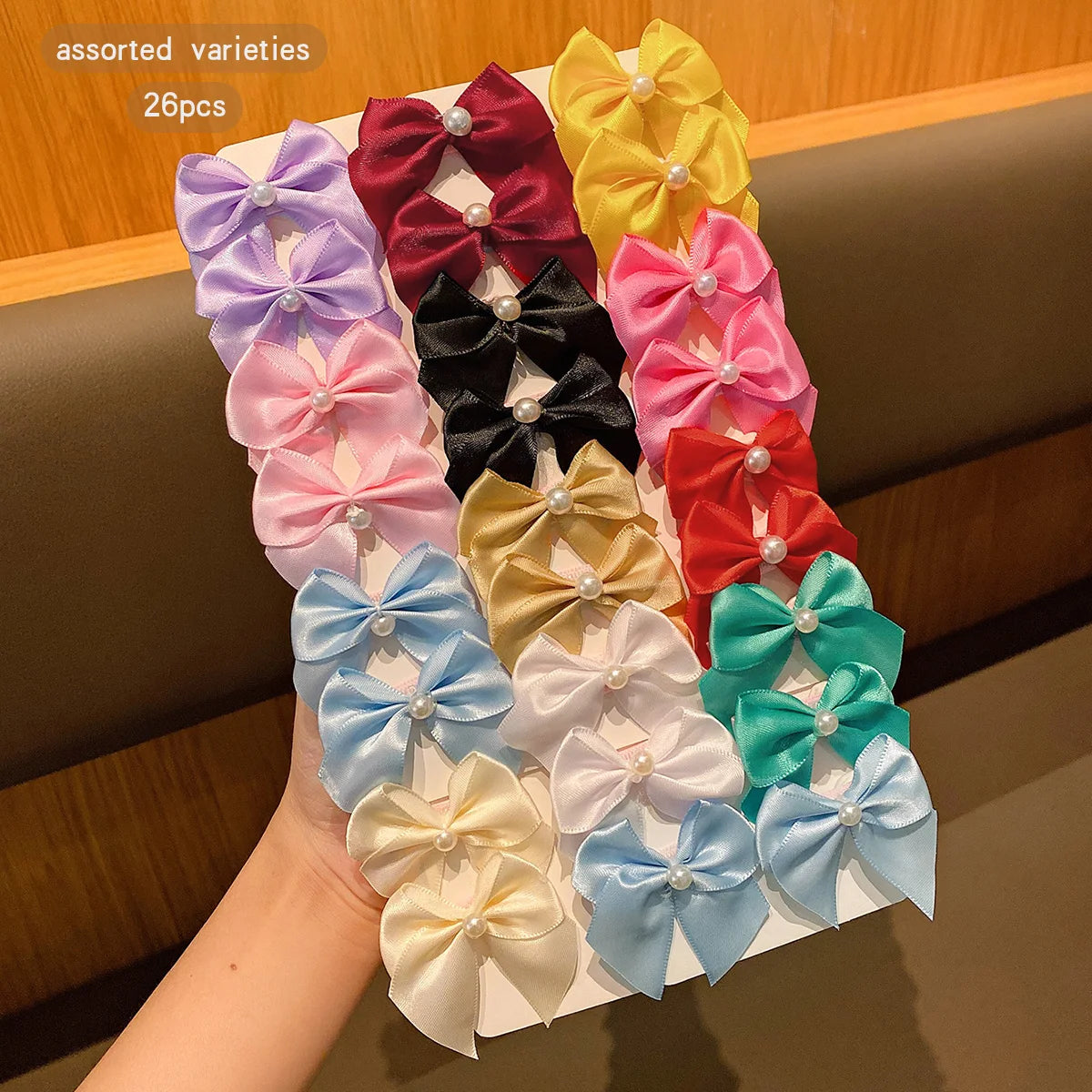 Assorted varieties of fabric hair clips in various shades including pink, purple, red, black, and yellow.