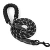 Black reflective nylon dog leash with a padded handle coiled and lying on a white background.