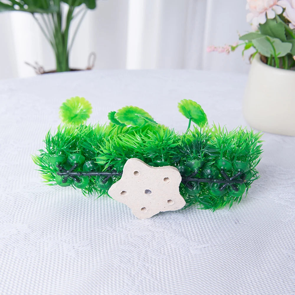Planta acuática artificial con musgo y hojas verdes brillantes sobre base de cerámica