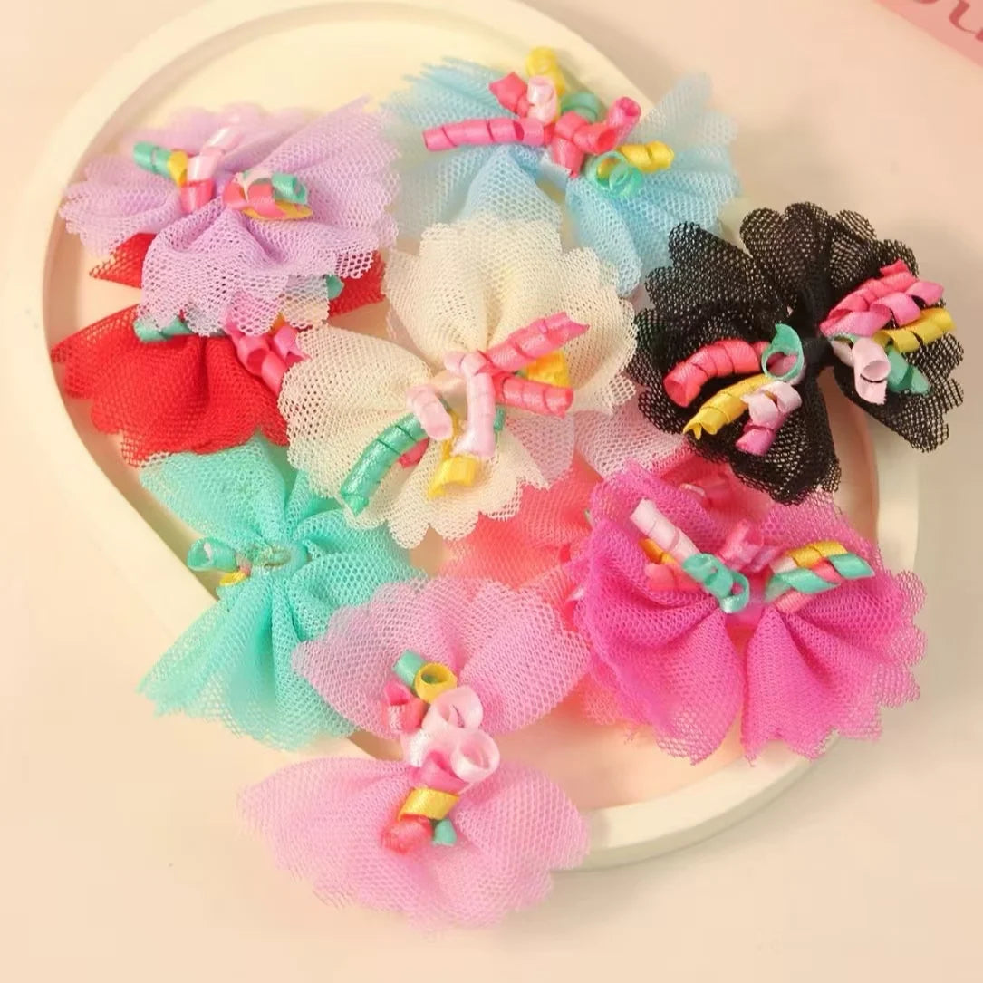 A collection of colorful lace dog hairbows in shades of pink, blue, red, and white.