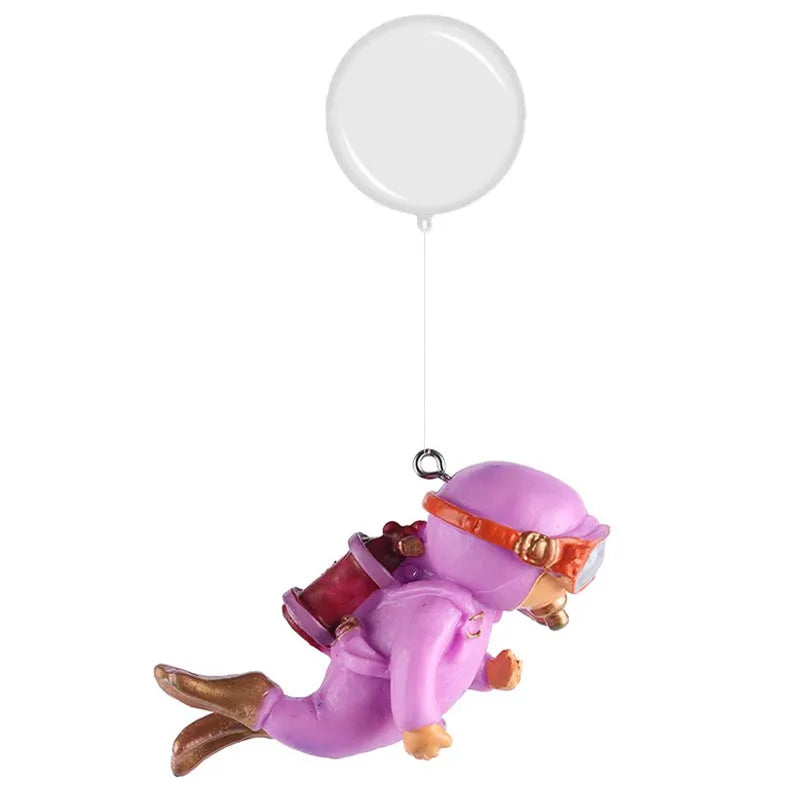 A purple resin mini diver aquarium ornament with orange accents is suspended by a white balloon.