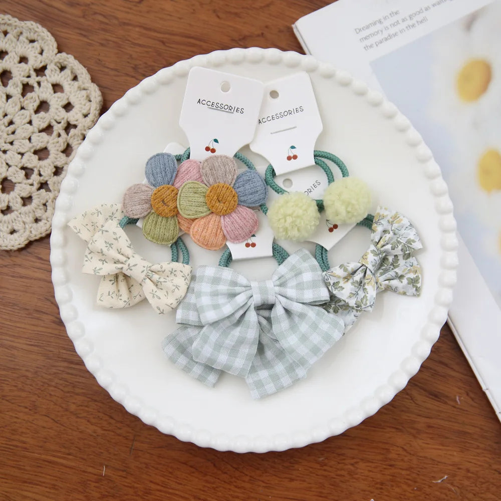 Collection de nœuds élastiques colorés et texturés présentés sur une assiette blanche.