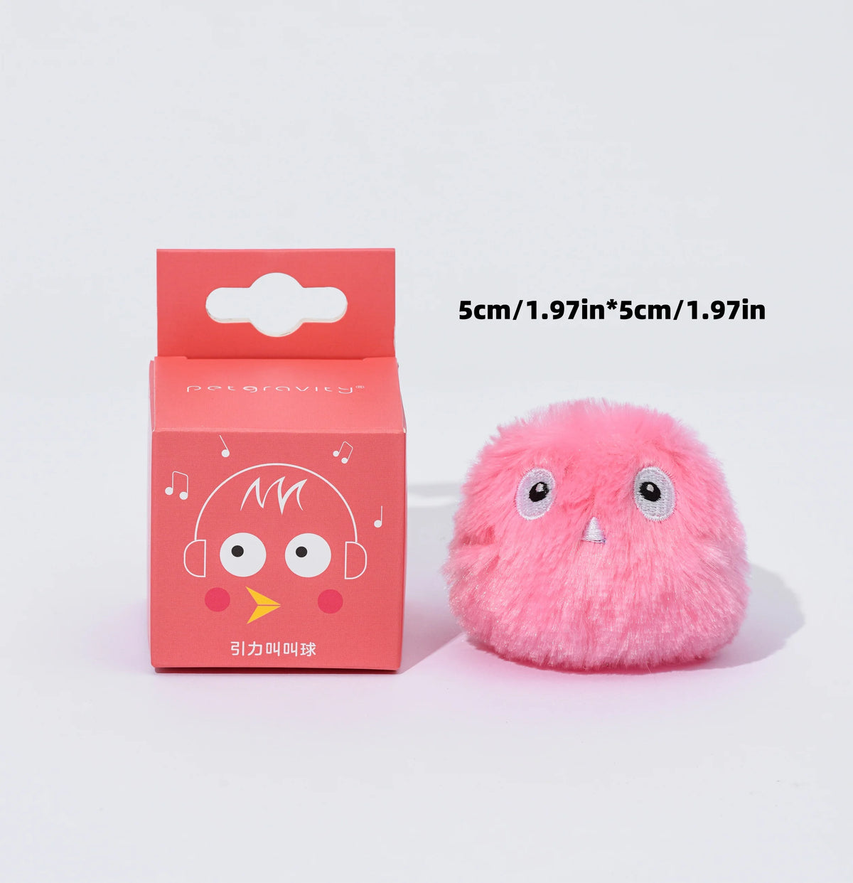 Rosa, flauschiges Plüschkatzendrehball mit großen Augen und kleiner Nase neben der Verpackung.