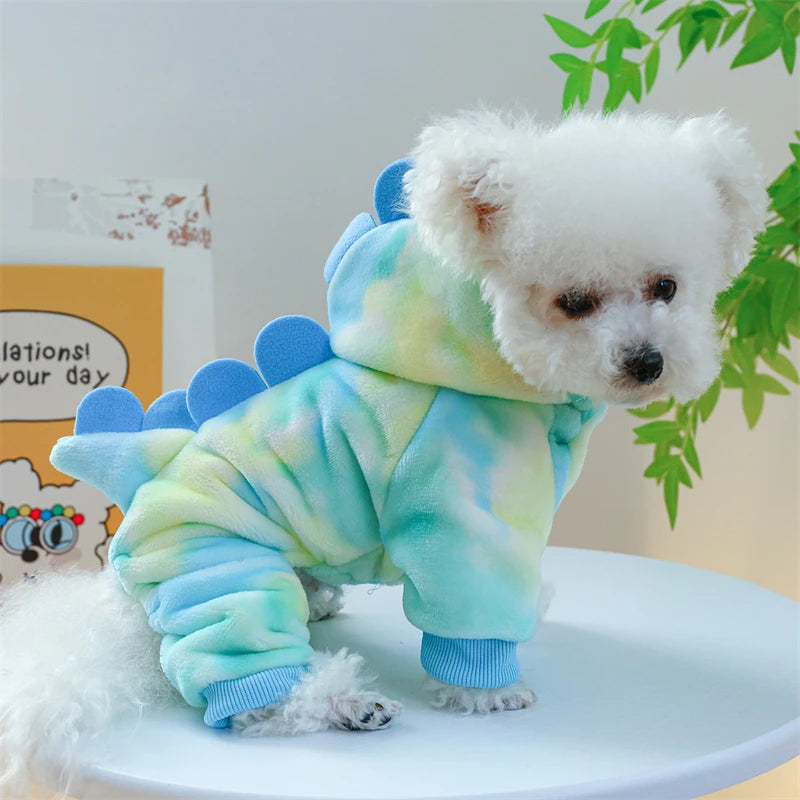 A fluffy white dog plush wearing light blue and green fleece overalls.
