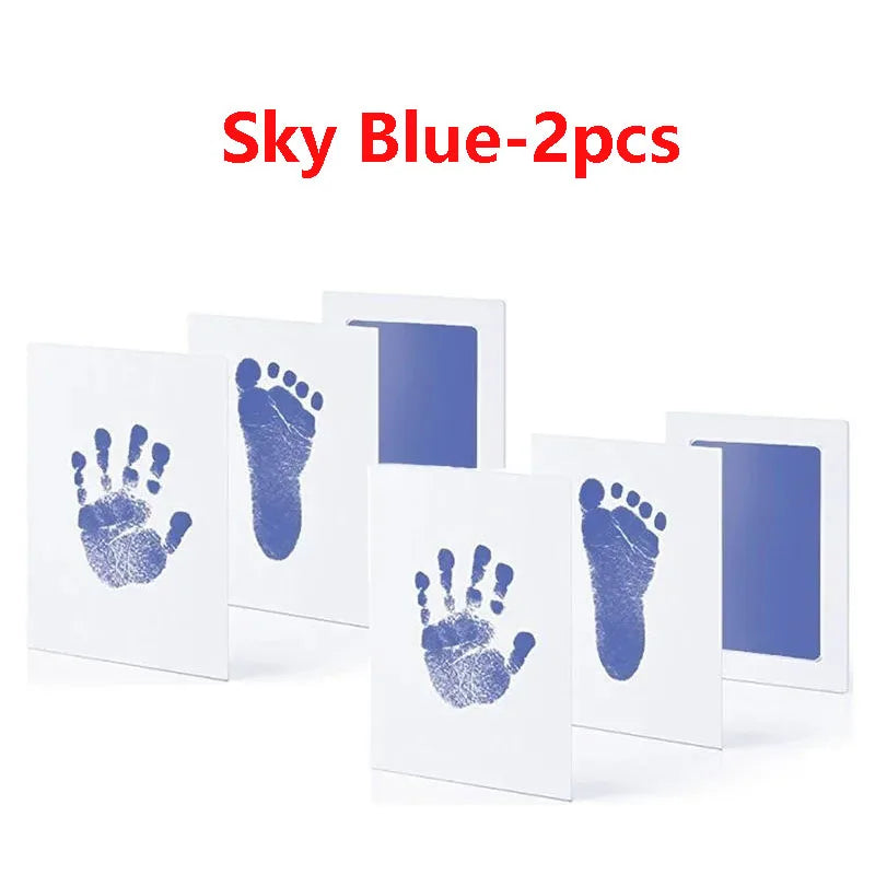Deux cartes blanches montrant des empreintes de main et de pied bleues pour souvenirs de bébé