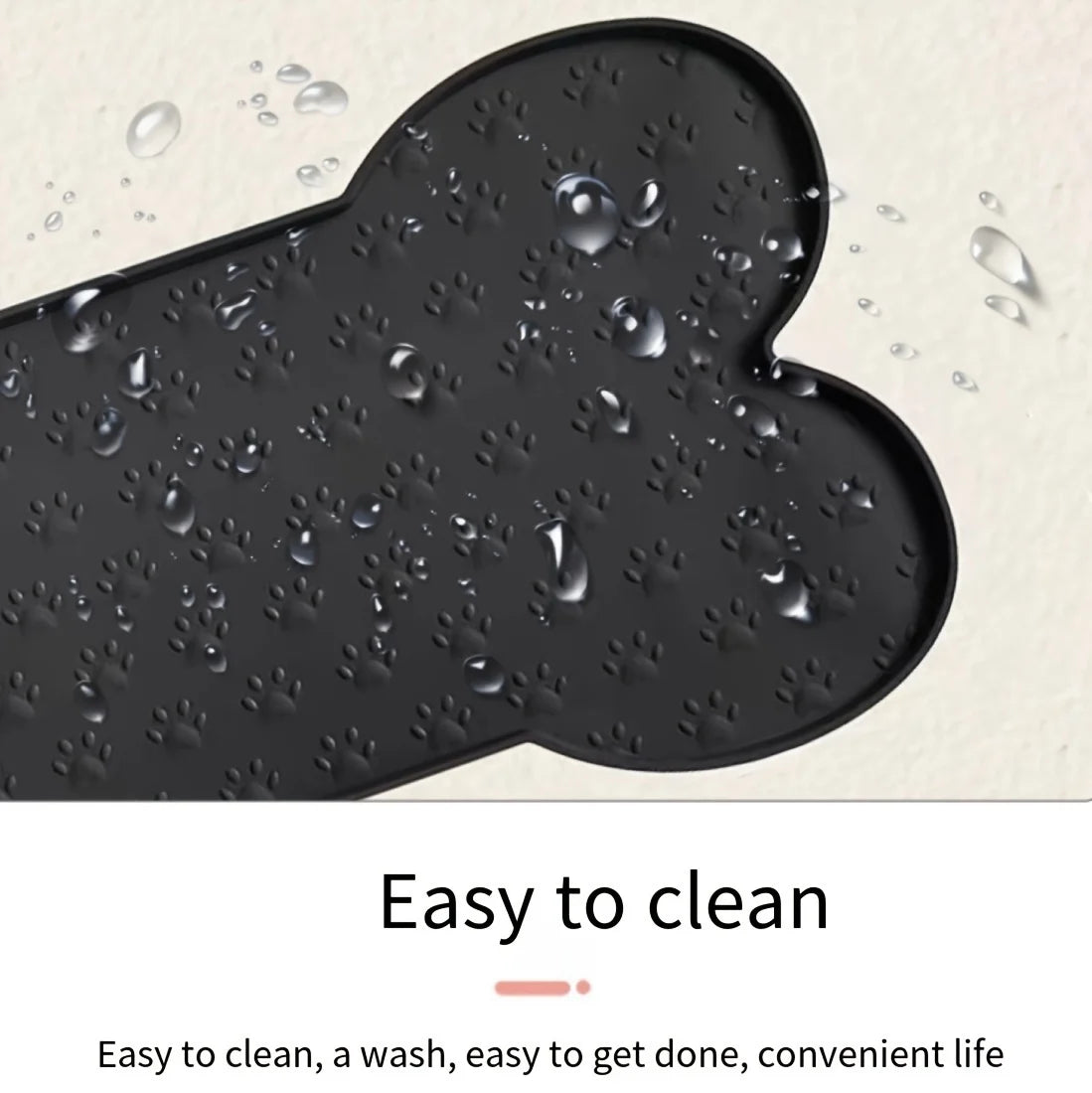A black non-slip silicone dog feeding mat with raised edges showing water droplets on its surface.
