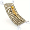 A small yellow lizard is resting inside a woven natural fiber hammock lounger.