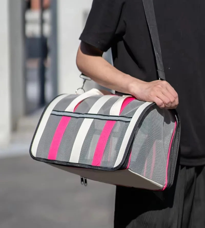 A person is carrying a lightweight foldable mesh travel carrier bag with striped pink and white accents.