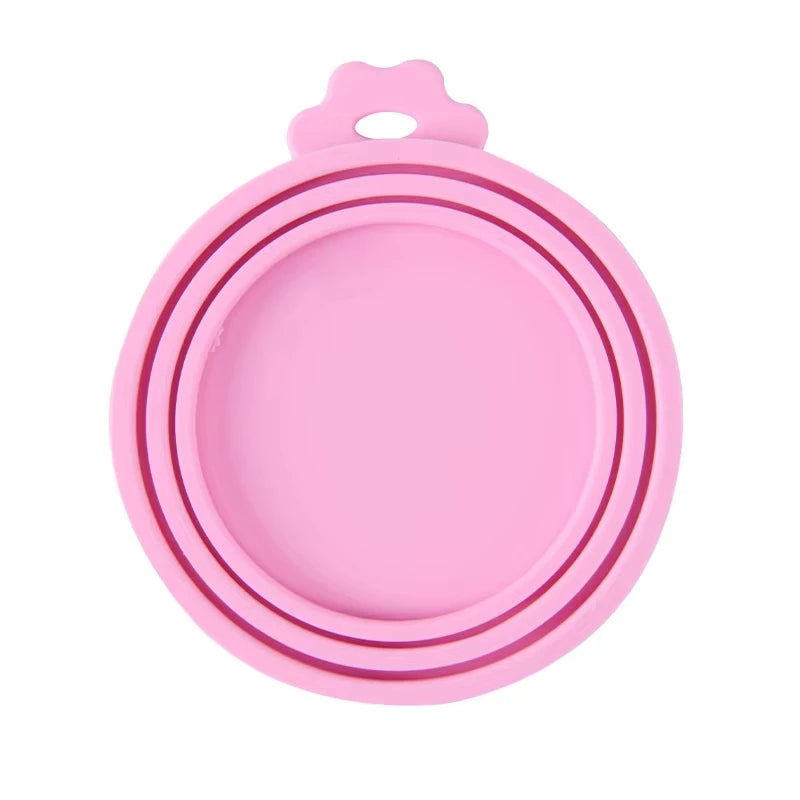 Pink reusable silicone pet food can lid with a spoon.