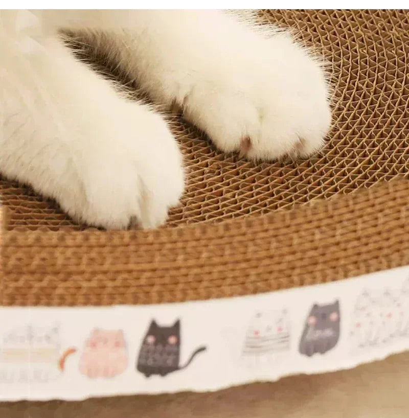 A white cat paw rests on a brown corrugated pad used as a cat scratcher.