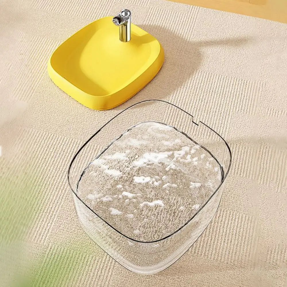 A yellow pet drinking fountain with a metal spout is shown on a light-colored surface.
