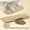 A gray cat is resting on a beige hemp rope scratching pad and lounger, with loose hemp rope material nearby.