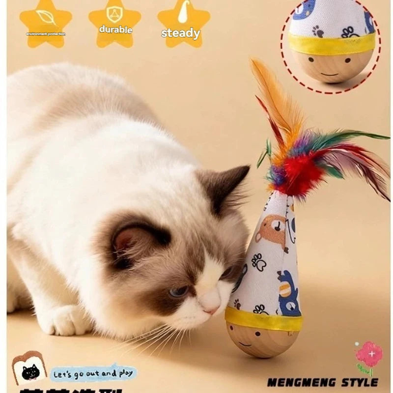 A fluffy white and gray cat is looking at an interactive feather wobble toy designed for indoor play.