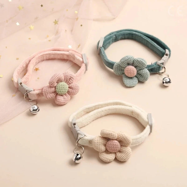Three adjustable cat collars in pink, teal, and cream colors with flower embellishments