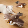 A white cat and a brown bird toy are shown interacting on a wooden surface.