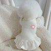 A white pet princess dog dress with flutter sleeves is displayed on a fluffy white surface.