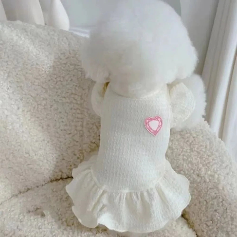 A white pet princess dog dress with flutter sleeves is displayed on a fluffy white surface.