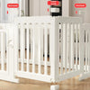 White indoor pet playpen with vertical bars and a corner buckle, shown on a wooden floor.