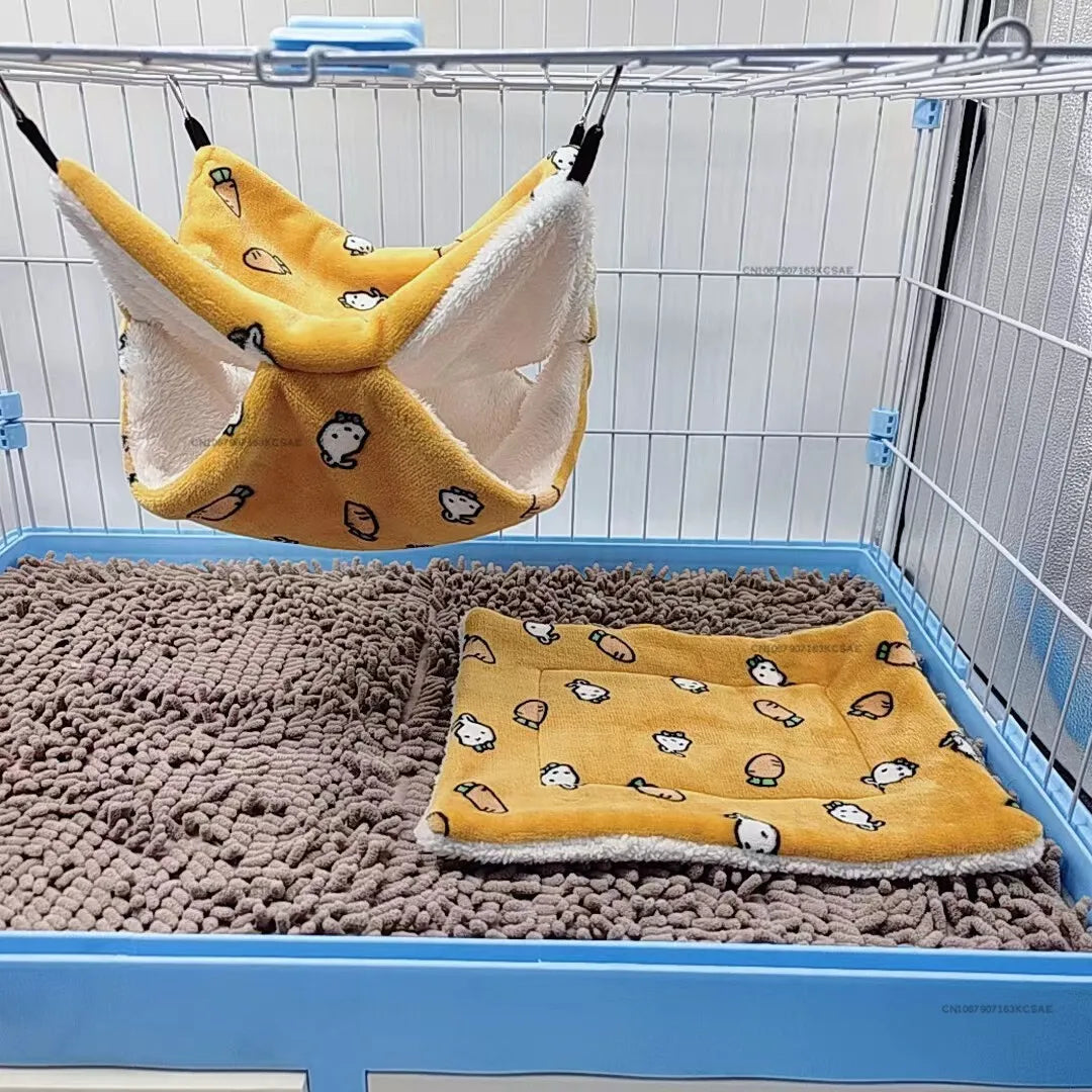 A yellow and white fleece pet bed mat is hanging inside a blue wire cage, resting on a gray textured mat.