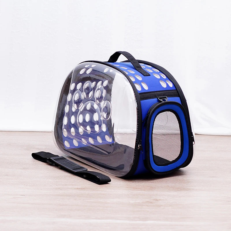 A blue and white transparent foldable pet travel carrier with a black shoulder strap.