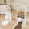 A white automatic pet feeder containing dry food and a separate compartment for water, viewed through a wire mesh cage.