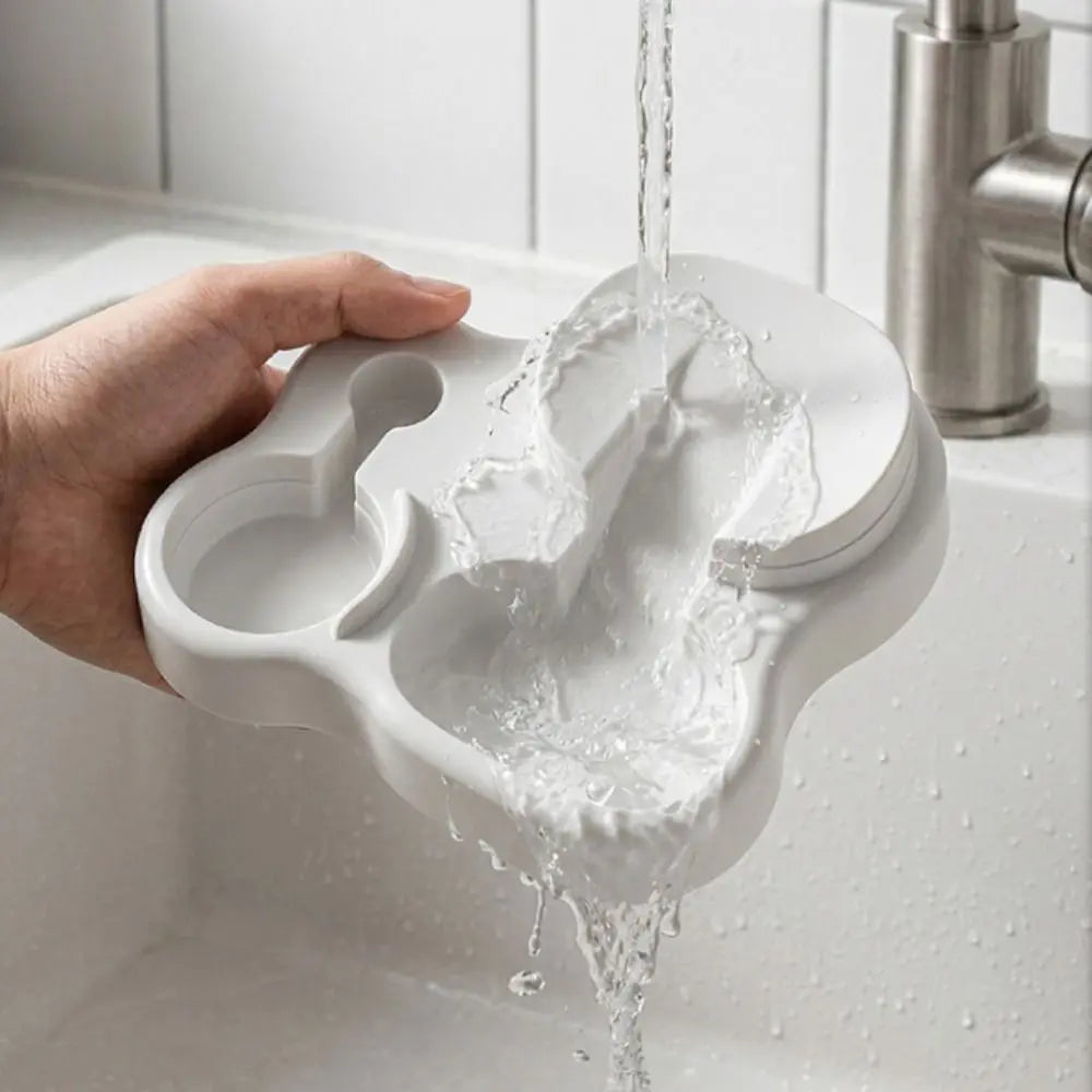 A hand pours white powder into a 2-in-1 mushroom cat feeder and water dispenser placed in a sink.