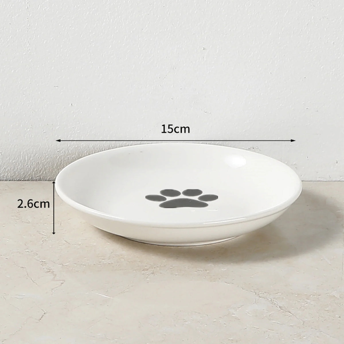 Weiße Keramikschale für Haustiere mit Pfotenabdruck-Design, vor hellem Hintergrund.