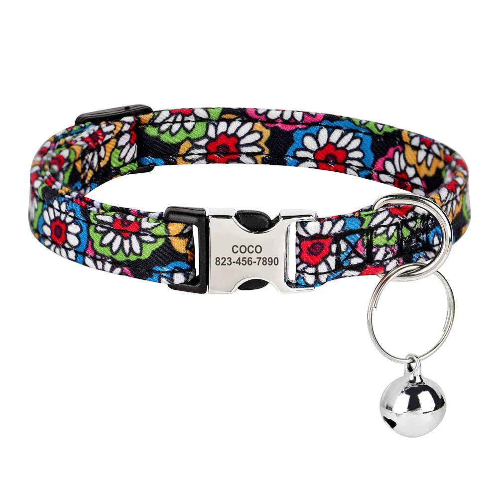 A colorful printed cat collar with a black strap and silver buckle and attached ID tag.