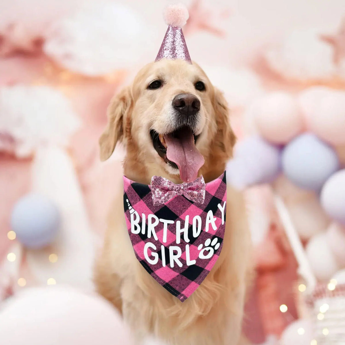 A golden retriever dog wearing a pink birthday hat, bandana, and bow tie for a party.