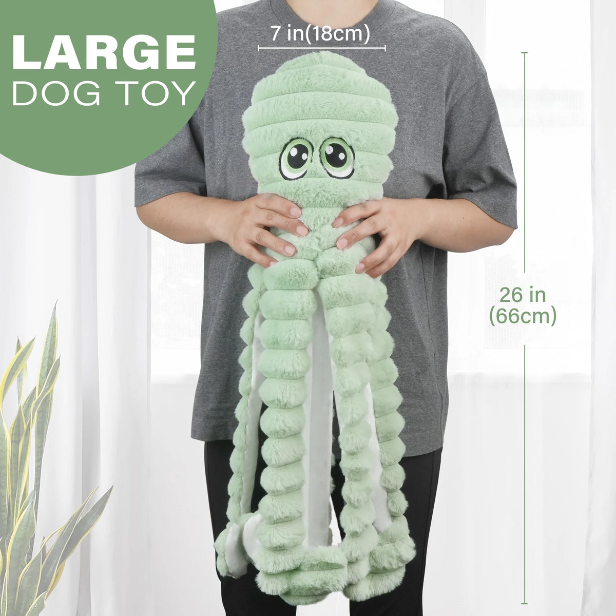 Eine Person hält ein großes, hellgrünes Plüschtier in Form eines Oktopus für Hunde.