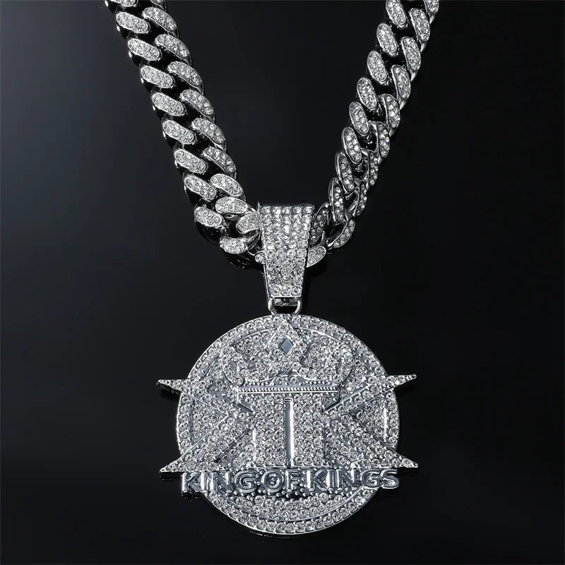A silver iced out letter and animal pendant on a Cuban link chain necklace