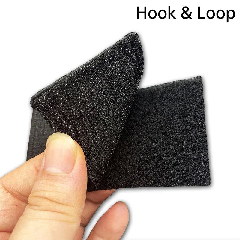 A hand holds a black Hook & Loop training patch, showing its textured surface and thickness.