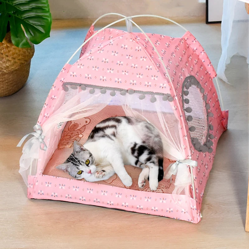 Un lit pour animal en forme de fleur rose semi-fermé avec une cage en filet contenant un petit chaton tigré.