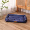 A navy blue corduroy pet sofa bed for dogs and cats resting on a light wood floor.