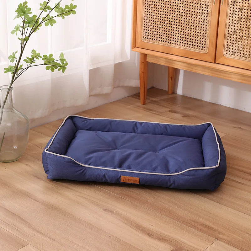 A navy blue corduroy pet sofa bed for dogs and cats resting on a light wood floor.