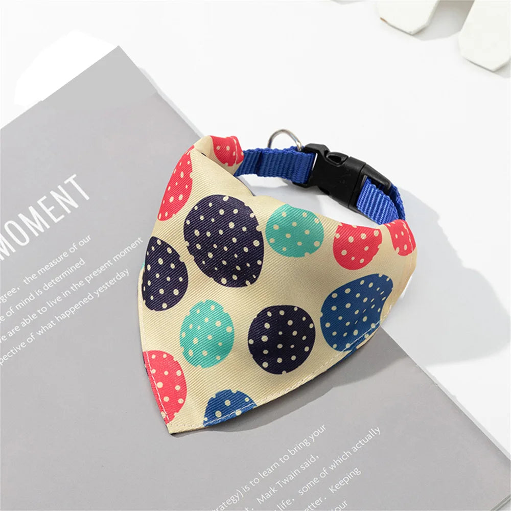 A beige bandana with a sweet print of multicolored polka dots is displayed on a gray surface.