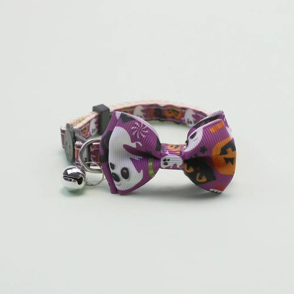 A purple Halloween pet collar featuring a bow tie and bell, with a patterned strap.