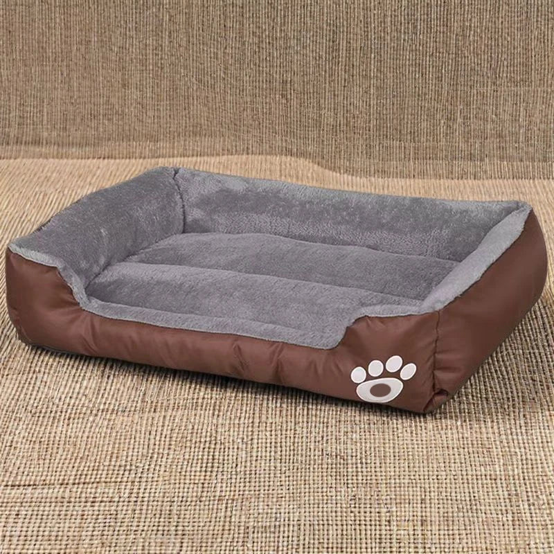 A brown dog bed with a gray plush cushion and a paw print design is shown on a textured surface.