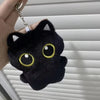 A black cat plush pendant with large yellow eyes is attached to a silver keychain ring.