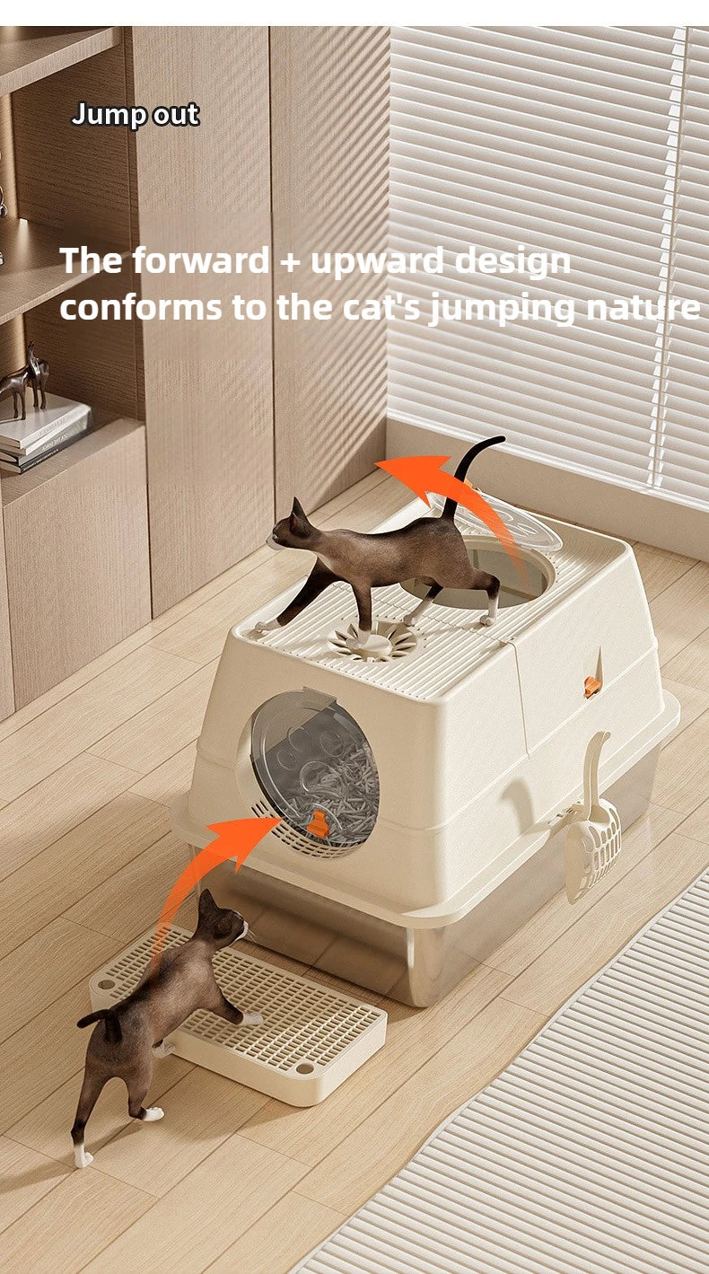 A brown cat is using a fully enclosed stainless steel litter box designed to conform to the cat's jumping nature.
