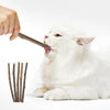 Eine weiße Katze leckt einen natürlichen Holzknochen.